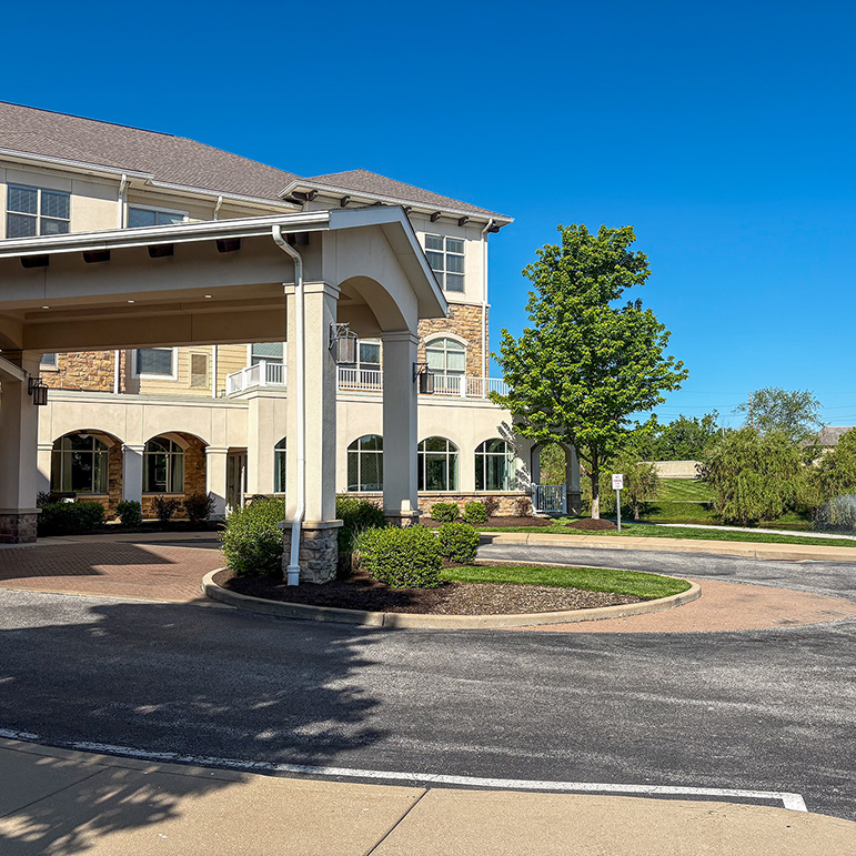 The exterior of The Henry Senior Living featuring landscaped grounds.